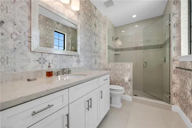 a bathroom with a double vanity sink toilet and shower