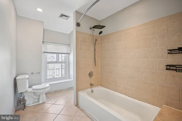 a bathroom with a bathtub shower and toilet