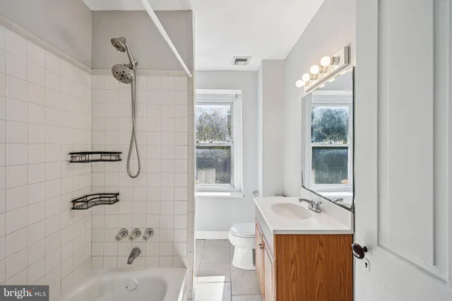 a bathroom with a sink vanity mirror and tub