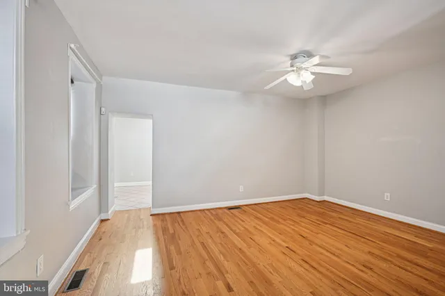 a view of empty room with wooden floor