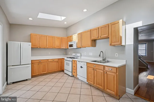 a kitchen with a sink a refrigerator and a stove top oven