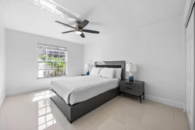 a bedroom with a large bed and a ceiling fan