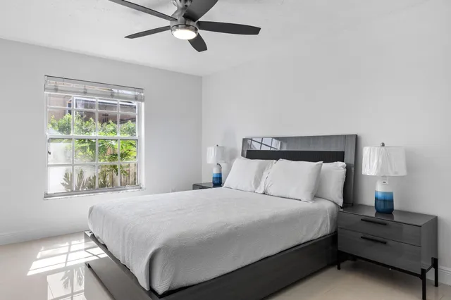 a spacious bedroom with a bed and a ceiling fan