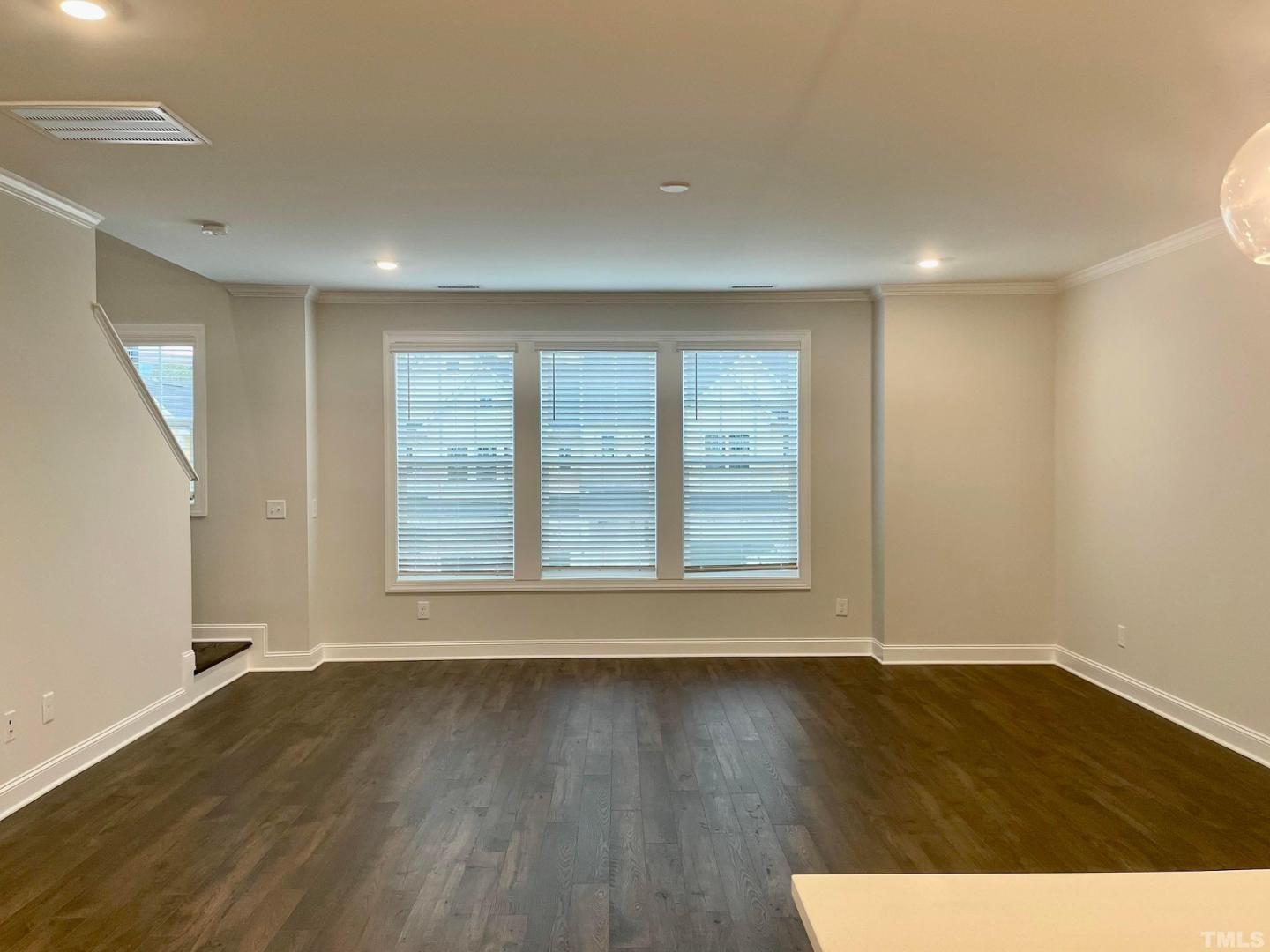 8425 Garnet Rose Drive Raleigh, NC 27615 - Photo 4 of 11 an empty room with wooden floor and windows