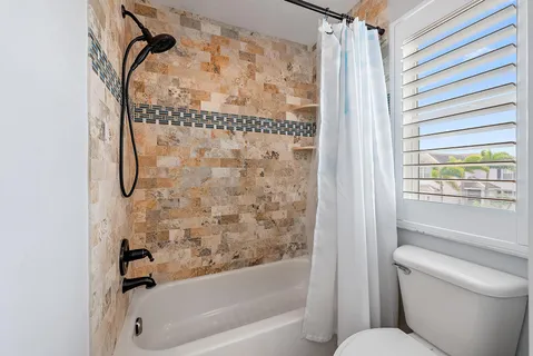 a bathroom with a toilet and a shower