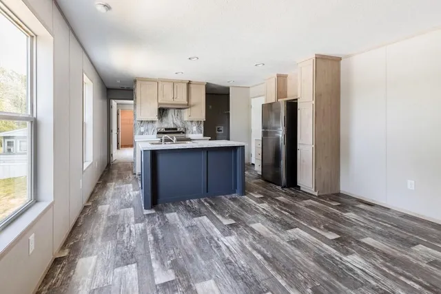 a kitchen with stainless steel appliances granite countertop a refrigerator and a stove top oven