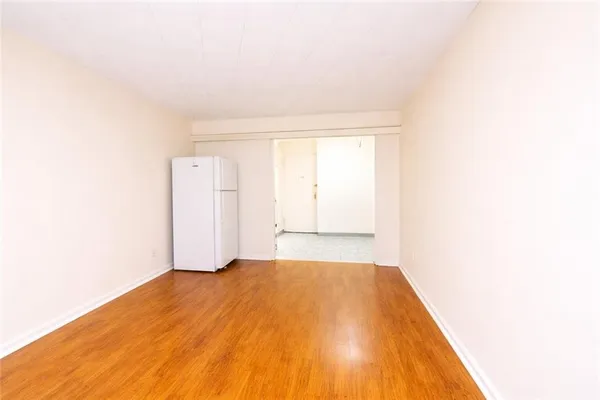 a view of a room with a wooden floor and white walls