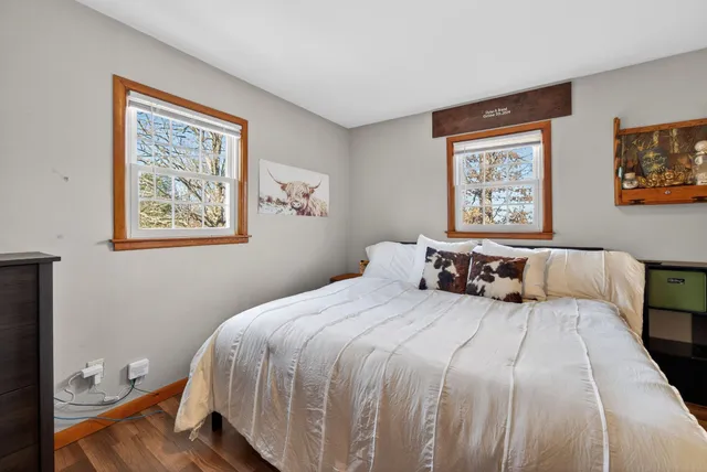 a bedroom with a bed and a painting on the wall