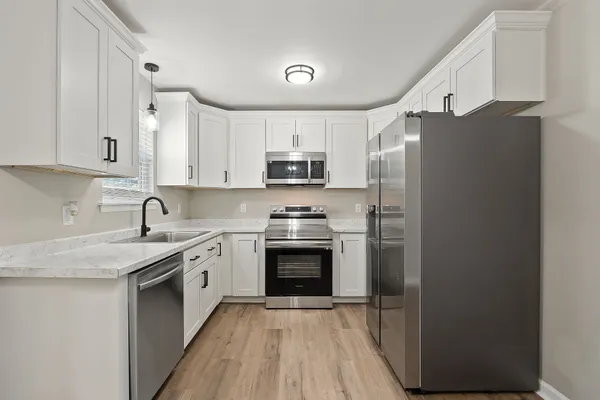 a kitchen with stainless steel appliances granite countertop a stove a sink and a refrigerator