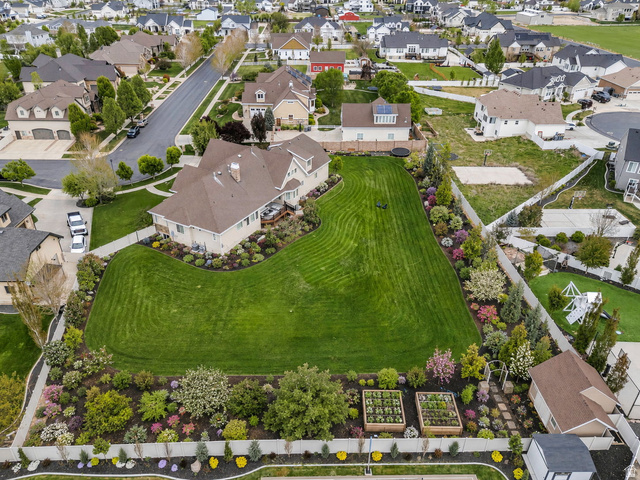 1355 West 1000 South Mapleton, UT 84664 - Photo 56 of 68 Expansive rear yard featuring a manicured lawn, lush landscaping, mature trees, and raised garden beds
