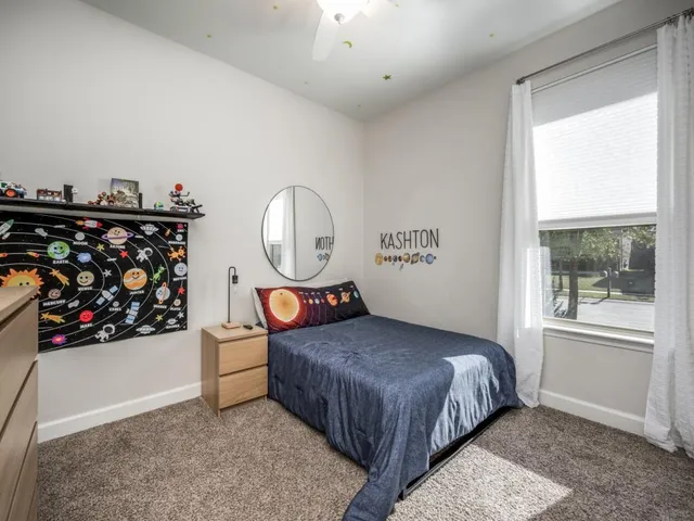 a bedroom with a bed a mirror and a window