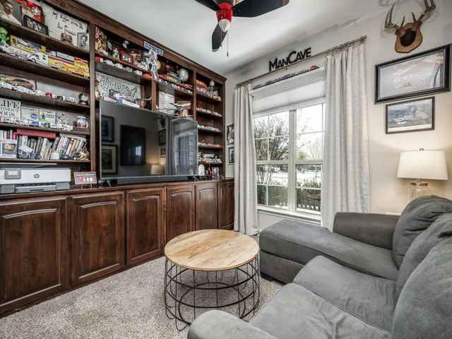a living room with furniture a flat screen tv and a large window