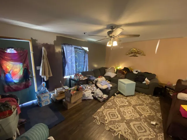 a living room with furniture a flat screen tv and a lamp