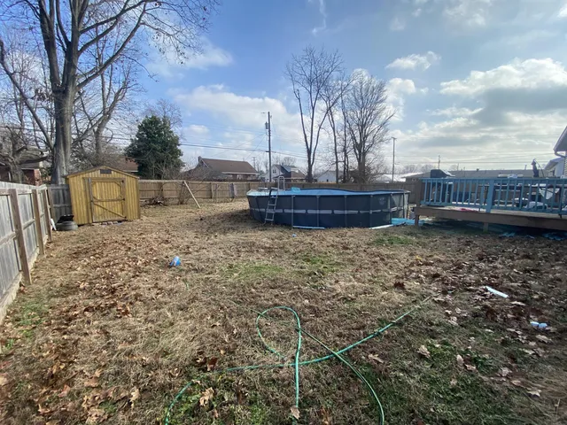 a view of a yard with wooden fence