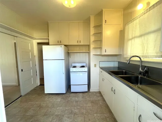 a kitchen with a sink cabinets and refrigerator
