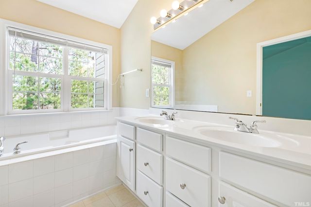 a bathroom with a large tub sink and window