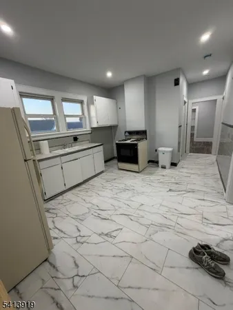 a large kitchen with kitchen island a sink stainless steel appliances and cabinets