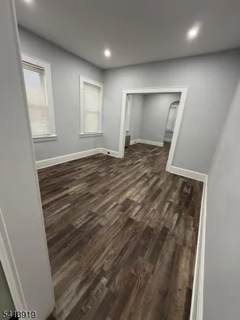 an empty room with wooden floor and window