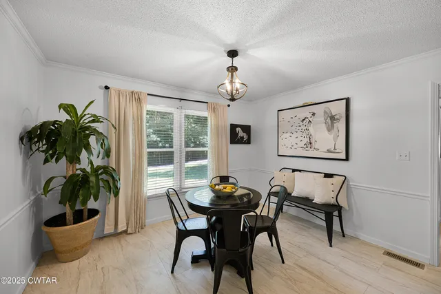 a dining room with furniture and potted plants