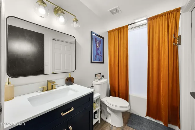 a bathroom with a sink a toilet and mirror