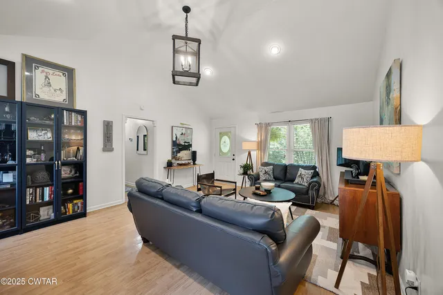 a living room with furniture a lamp and a window