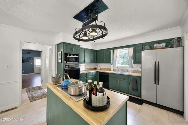 a kitchen with stainless steel appliances granite countertop a sink dishwasher and a refrigerator with wooden floor