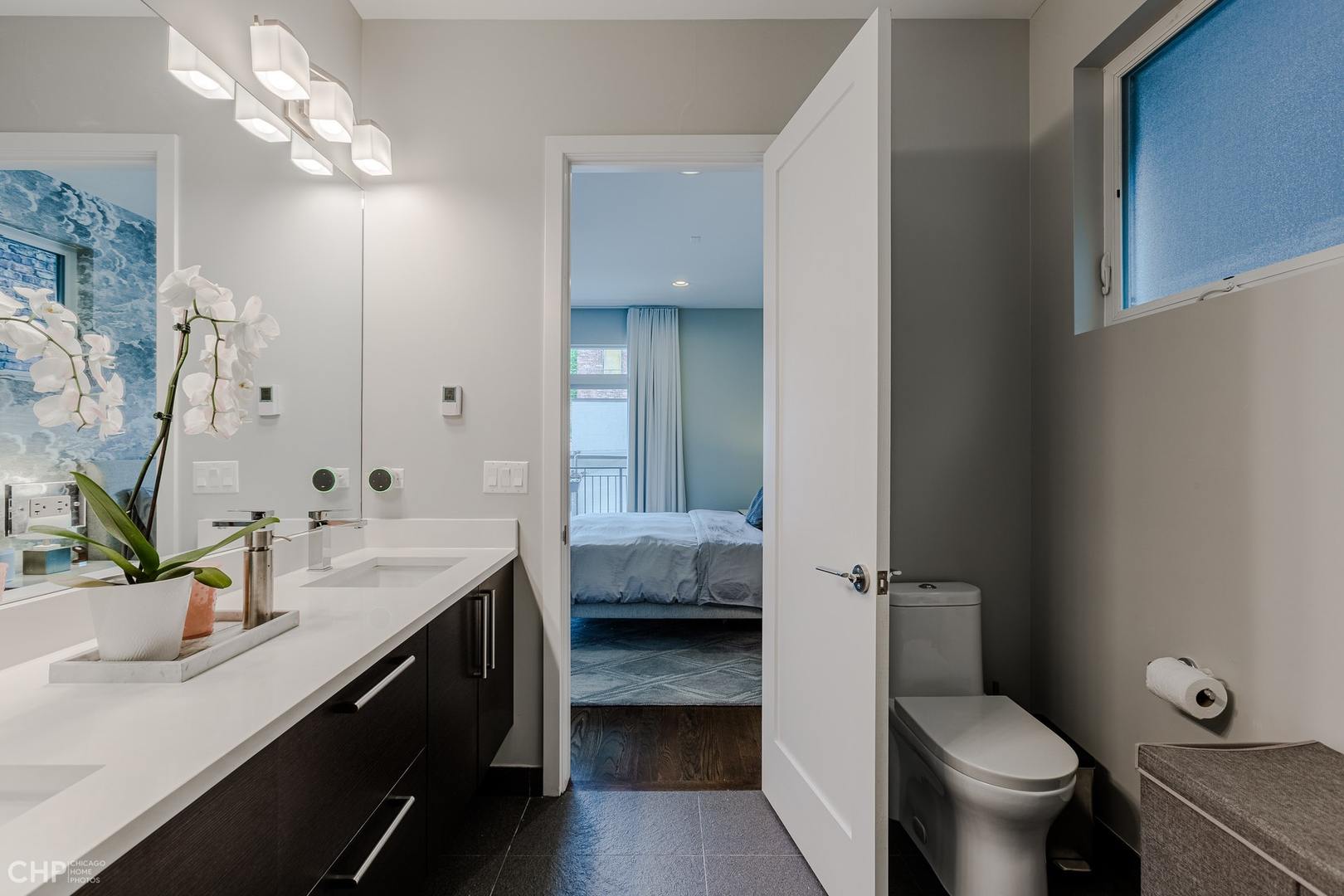 1033 South Racine Avenue, Unit 1S Chicago, IL 60607 - Photo 19 of 32 a bathroom with a granite countertop sink a toilet and a mirror