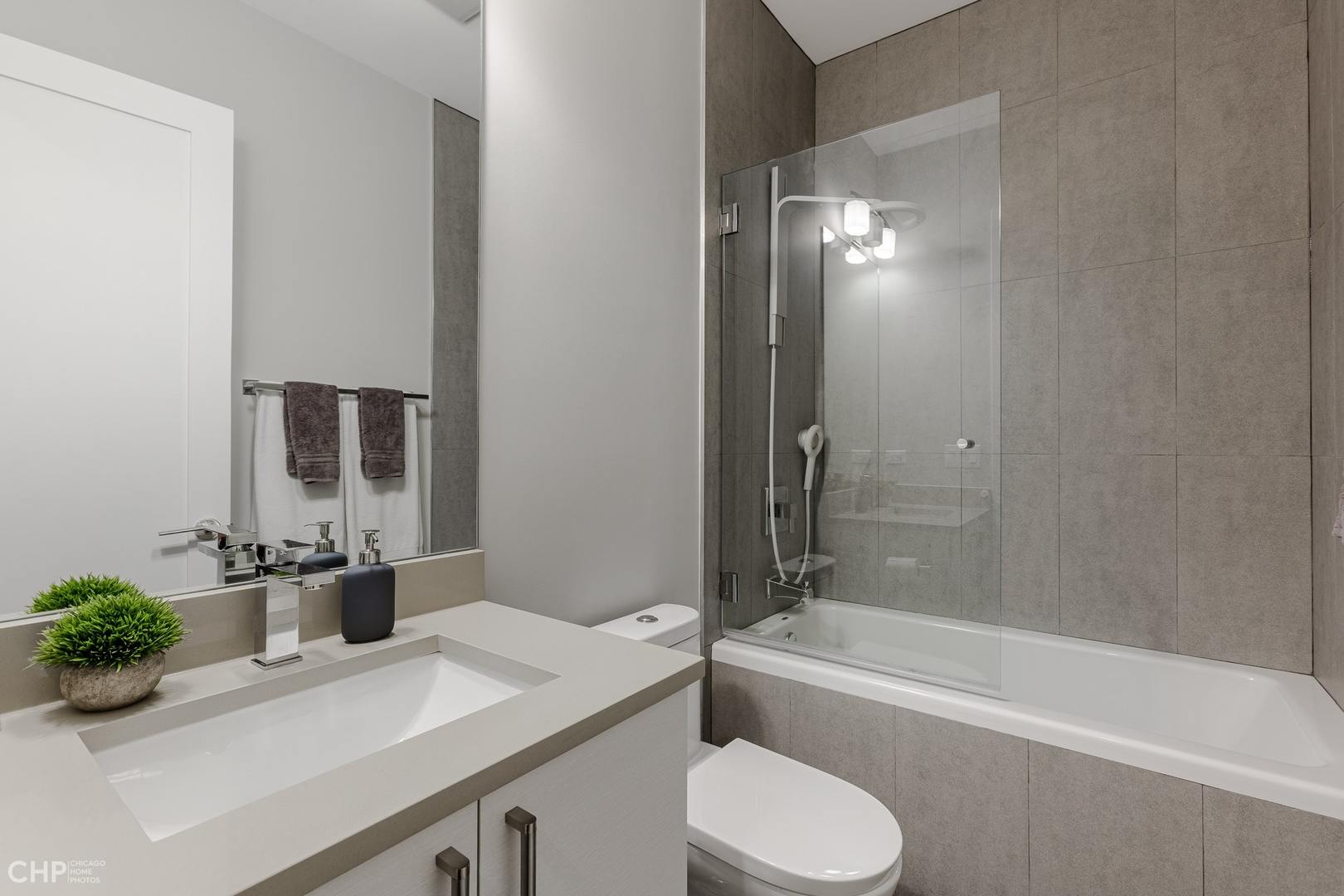 1033 South Racine Avenue, Unit 1S Chicago, IL 60607 - Photo 24 of 32 a bathroom with a granite countertop sink toilet and shower