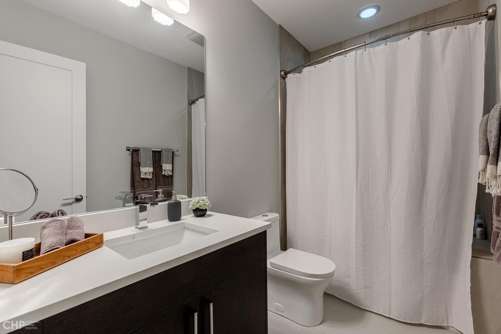 1033 South Racine Avenue, Unit 1S Chicago, IL 60607 - Photo 26 of 32 a bathroom with a double vanity sink toilet and a mirror