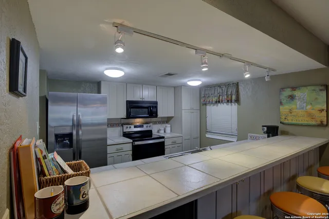 a kitchen with stainless steel appliances granite countertop a refrigerator and a sink