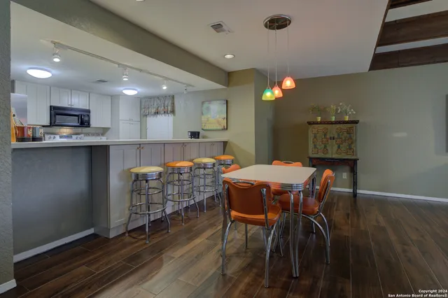 a dining room with a table chairs and a kitchen view