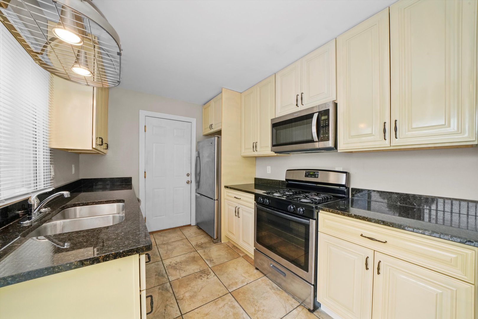 300 Hadleigh Road Bolingbrook, IL 60440 - Photo 12 of 45 a kitchen with granite countertop a sink a stove top oven and cabinetry
