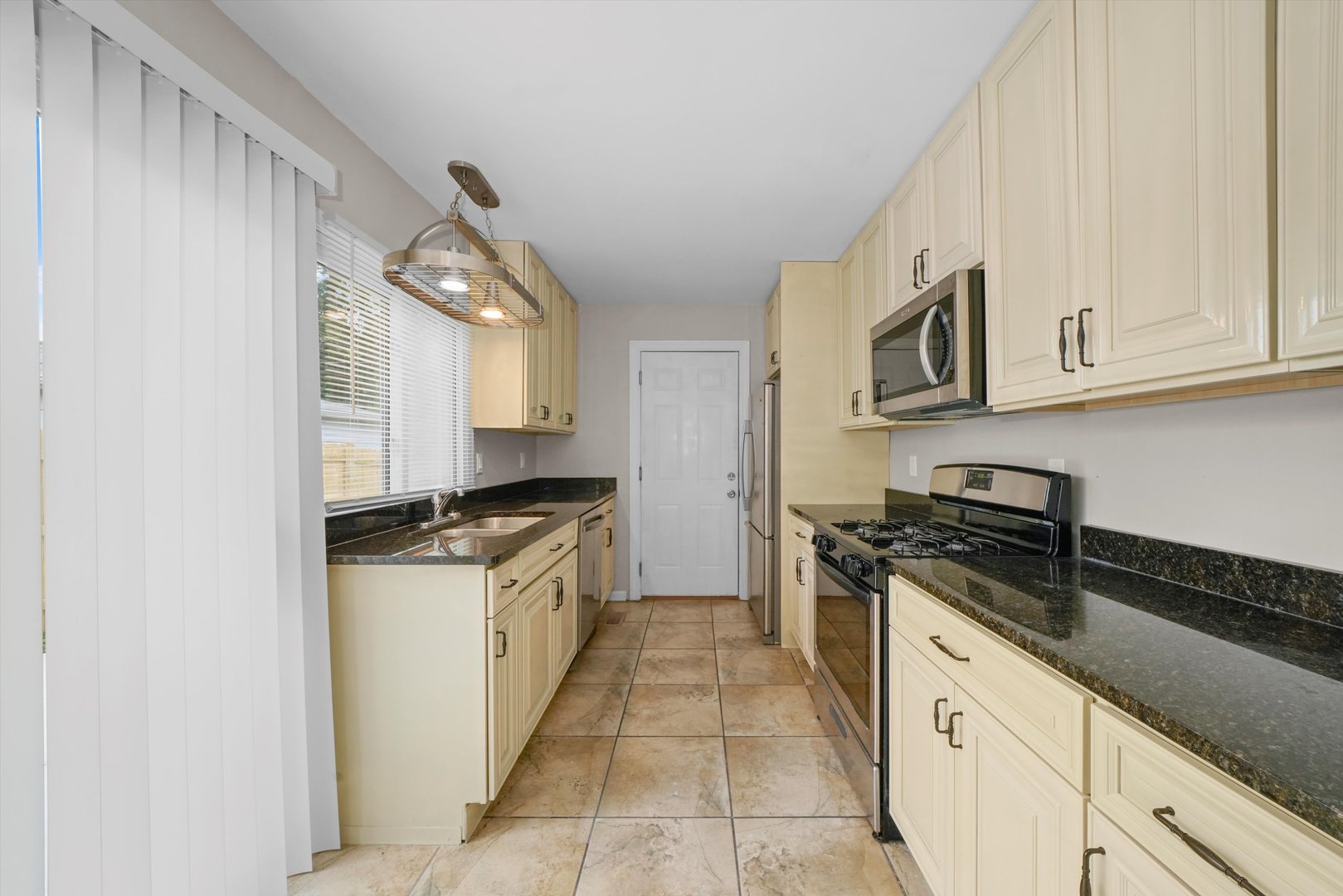 300 Hadleigh Road Bolingbrook, IL 60440 - Photo 13 of 45 a kitchen with stainless steel appliances granite countertop a stove a sink and a microwave