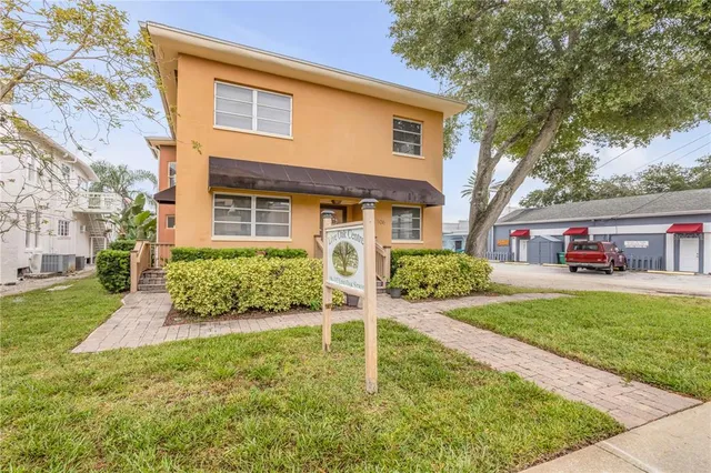 a cars parked in front of a brick house next to a yard