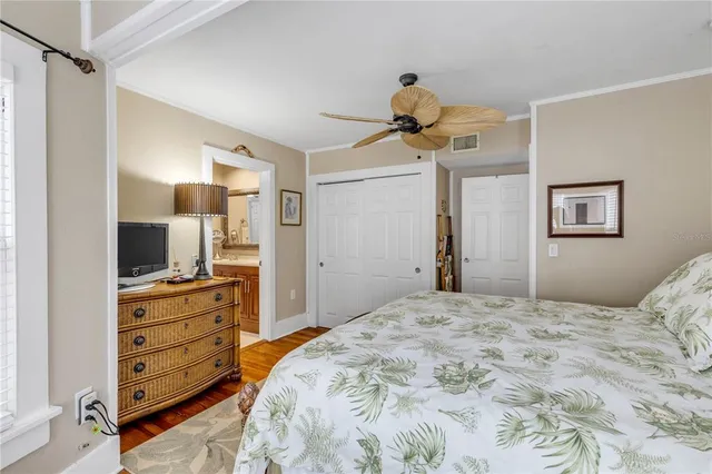 a bedroom with a bed and a large mirror on the dresser