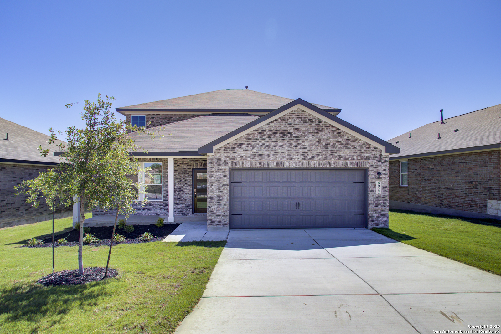 a view of a house with a yard and potted plants