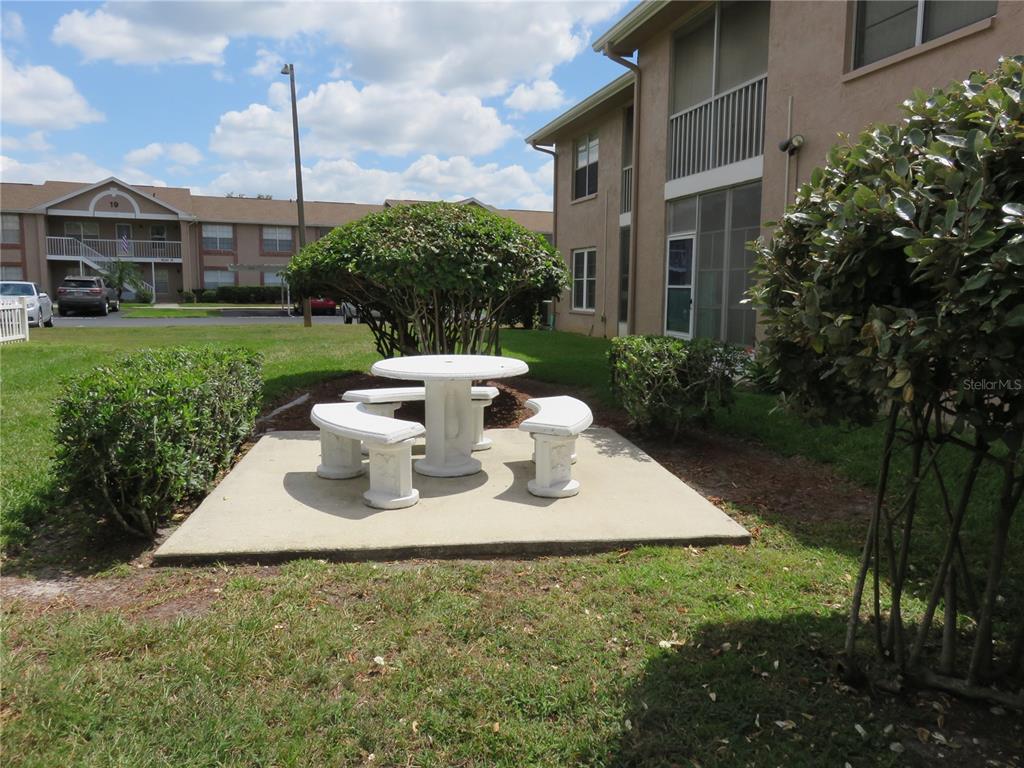 4911 Sunnybrook Drive, Unit 12 New Port Richey, FL 34653 - Photo 20 of 32 a view of a house with backyard sitting area and garden