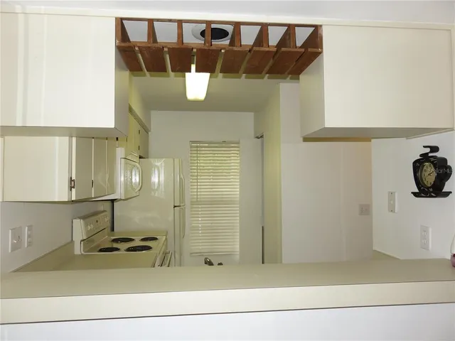 a kitchen with a stove a sink and white cabinets