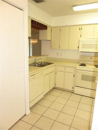 a white refrigerator freezer and a stove sitting inside of a kitchen