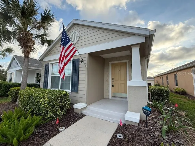 a view of a house with a small yard plants and couches chairs