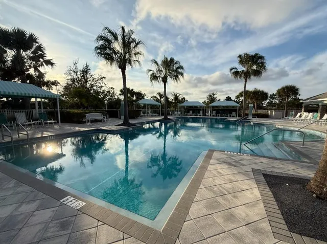 a living room with furniture a large window and dining table