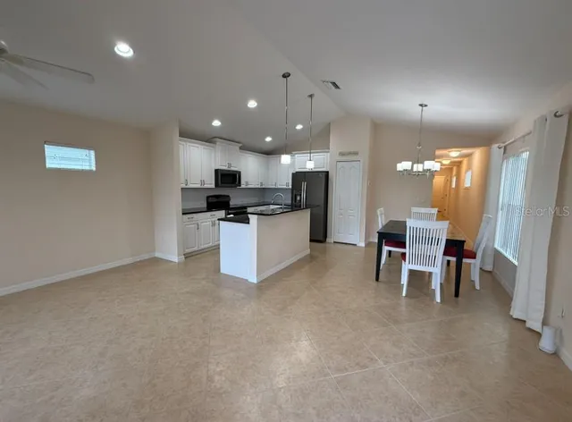 a view of kitchen with microwave and refrigerator