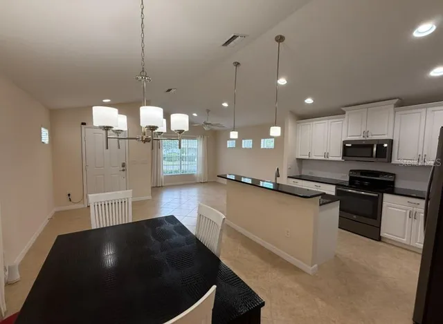 a kitchen with stainless steel appliances granite countertop a sink a stove and a refrigerator