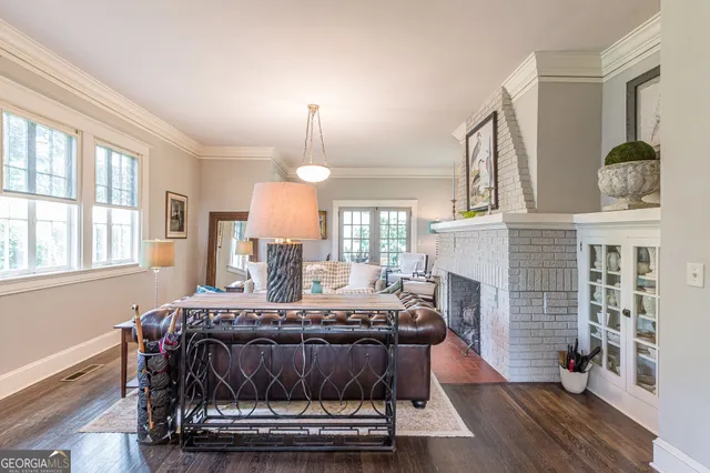 a living room with furniture a fireplace and wooden floor