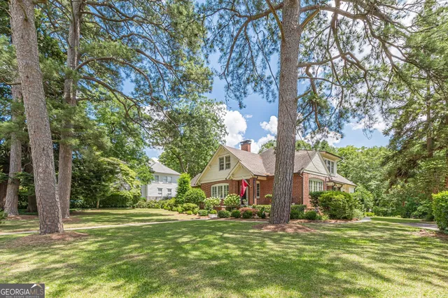 a front view of a house with a yard and trees