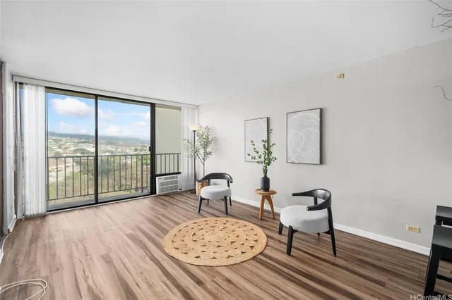 a living room with furniture large window and wooden floor