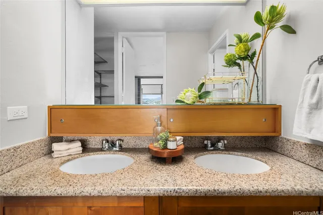 a bathroom with a granite countertop sink and a mirror
