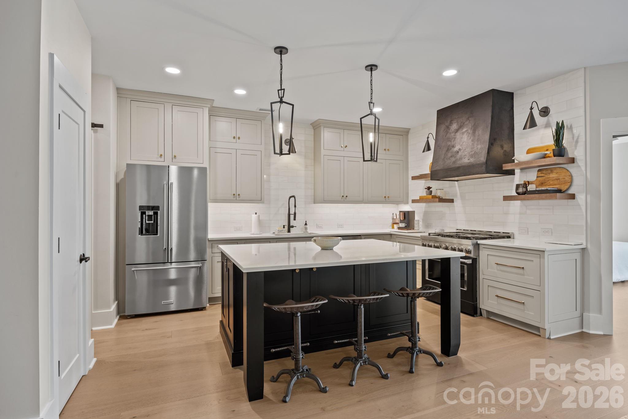 241 North Faulkner Way Davidson, NC 28036 - Photo 6 of 39 a kitchen with stainless steel appliances granite countertop a sink a stove a refrigerator and island with wooden floor