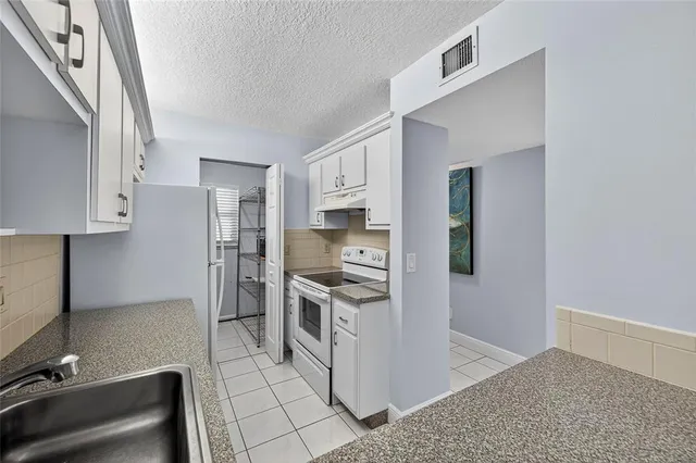 a kitchen with stainless steel appliances granite countertop a refrigerator stove and sink