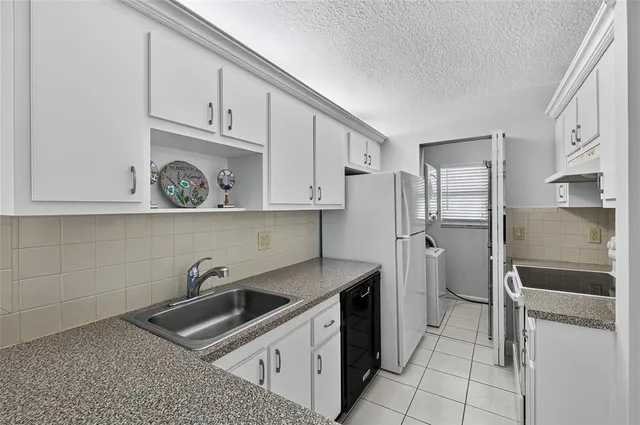 a kitchen with stainless steel appliances granite countertop a refrigerator and a stove